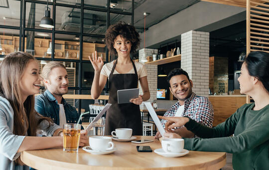 Une  serveuse accueillant des clients – gestion de restaurant