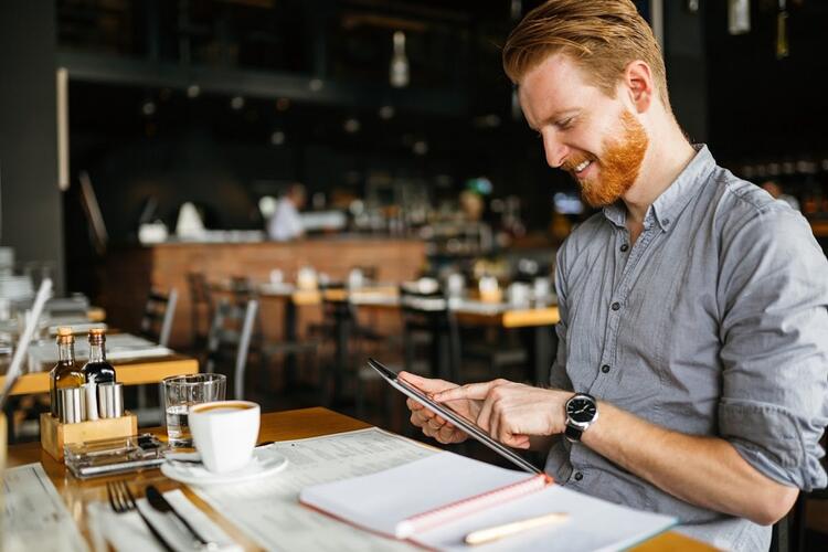uomo che guarda un iPad in un ristorante