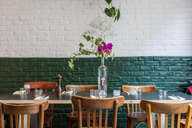 restaurant empty tables with green & white wall