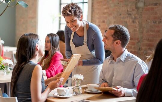 Friendly waitress serving couple at a restaurant